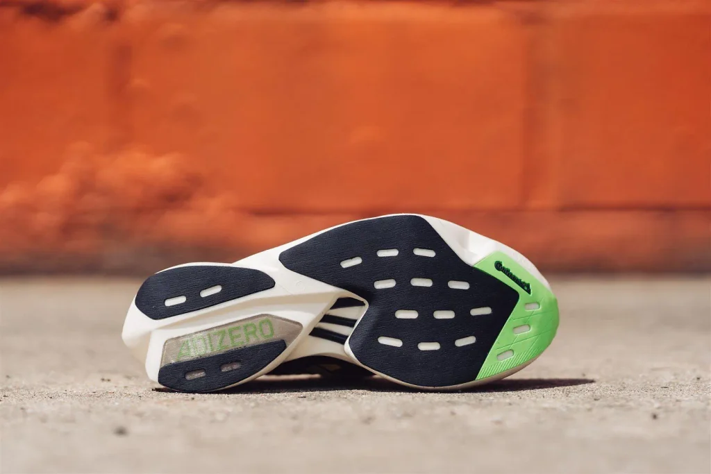 Adidas Adios Pro 3 running shoes on a city park track