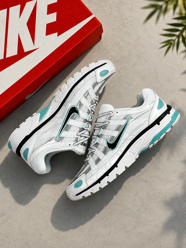 White and teal Nike P6000 sneakers beside a Nike shoebox
